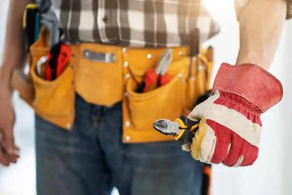 Reparador sosteniendo cortadores laterales en la mano — Foto de Stock