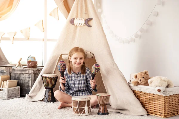 Little girl with maracas and djembe drums — Stock Photo, Image