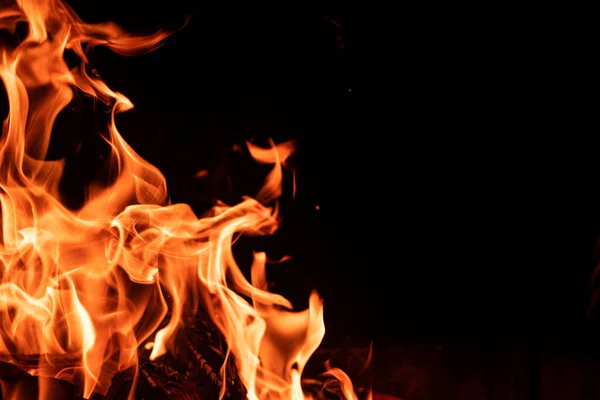 Огненное пламя на черном фоне — стоковое фото