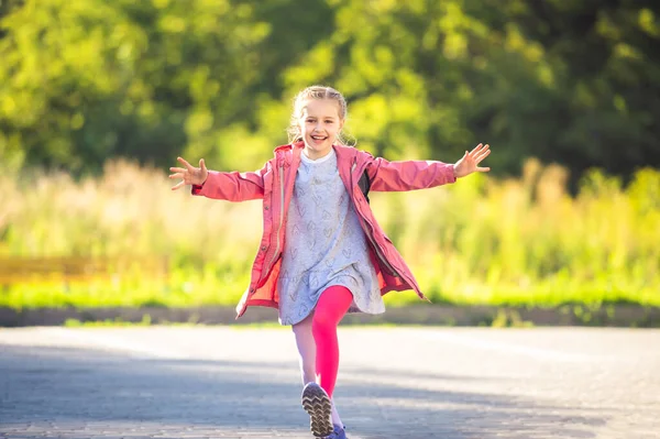 Счастливая маленькая девочка бежит после школы — стоковое фото