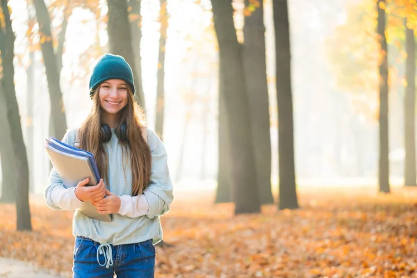 Felice ragazza della scuola nel parco di autunno — Foto Stock