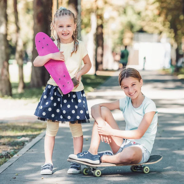 Chicas con patinetas en el parque — Foto de Stock