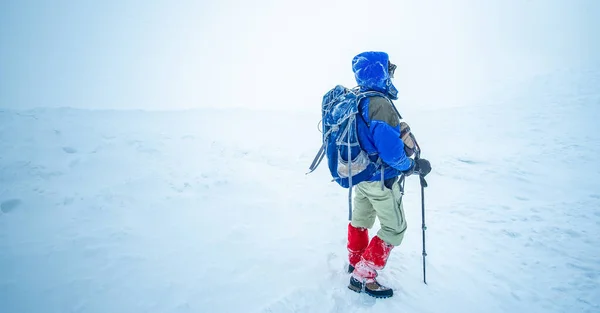 Karlı kış dağında ayakta duran yürüyüşçü — Stok fotoğraf