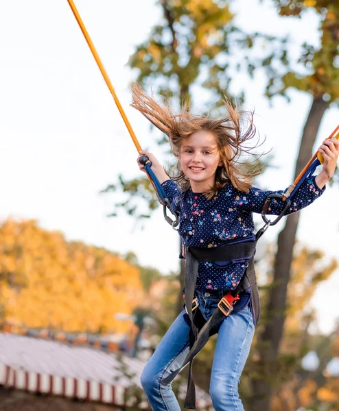 Leende liten flicka hoppar på studsmatta rep — Stockfoto