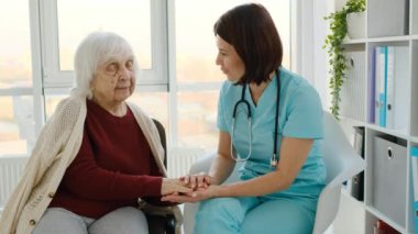 Klinikte kıdemli bir kadınla konuşan terapist.