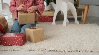 Küçük kız yeni yıl hediyelerini paketliyor.