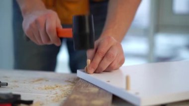 Tahta pervazı tokmakla tıkayan adam.