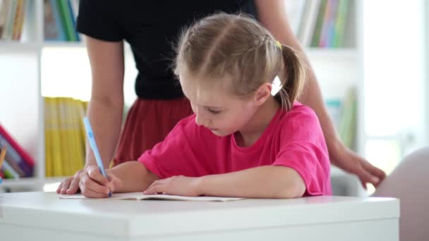 Primary schoolgirl writing in copybook at school — 비디오