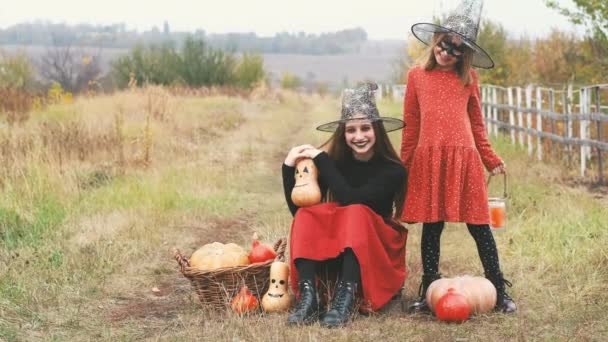 Girls with halloween makeup posing near pumpkins — стоковое видео