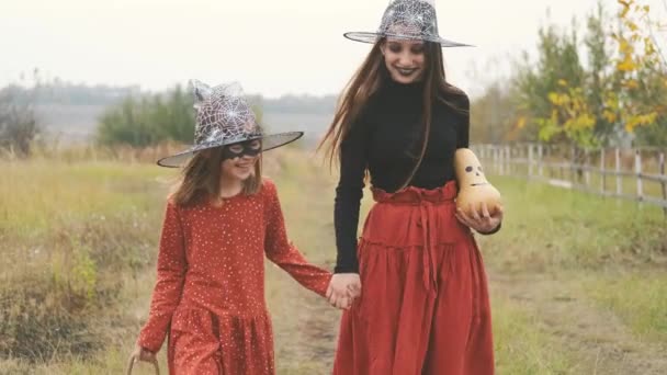Flickor i halloween kostymer gå hålla händer — Stockvideo