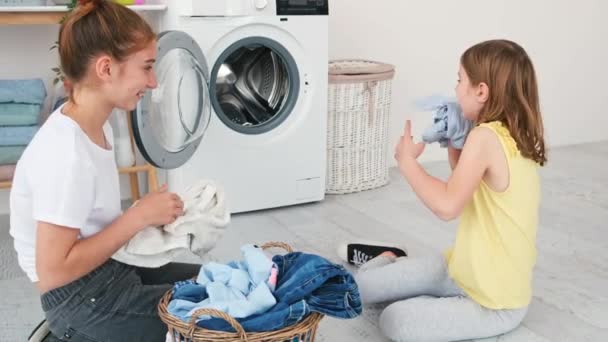 Meisjes spelen met wasgoed kleding voor het wassen — Stockvideo