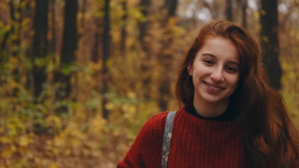 Νεαρό κορίτσι περπατά μέσα από το φθινόπωρο πάρκο — Αρχείο Βίντεο