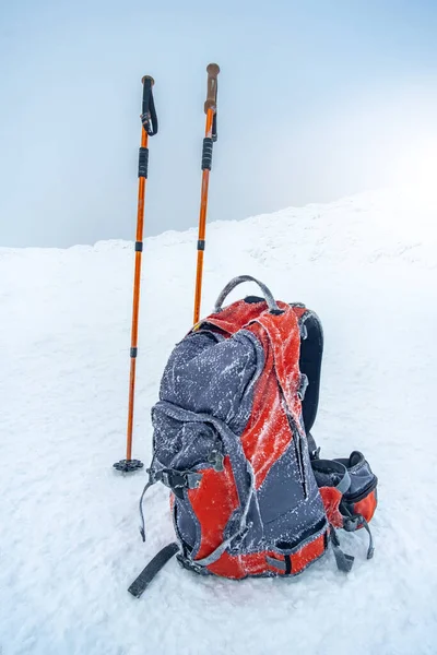 Trekking pinnar och ryggsäck på snö — Stockfoto