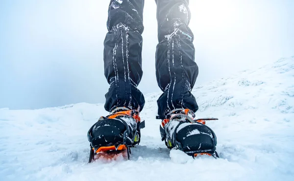 Man bär kramponger stående på snö — Stockfoto