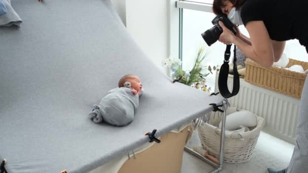 Kadın Fotoğrafçı Fotostudio Uyuyan Yeni Doğan Bebeğin Fotoğraflarını Çekiyor — Stok video