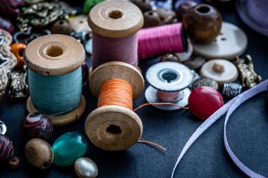 Koyu arkaplandaki eski ipliklerin ve eski düğmelerin üst görünümü