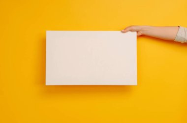 Sarı zemin üzerinde telif alanı olan beyaz tuval kağıdı boş duruyor. Metin için yeri olan boş bir pankart. Tasarım kavramı, sanat yaratıcılığı