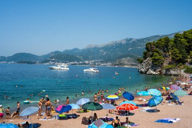 Budva, Montenegro - 27 July 2021: Beach in Sveti Stefan island in Montenegro with tourists. People resting on luxury resort in Adriatic sea