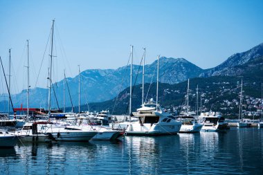 Luxury yachts port in Montenegro with mountains and city view. Boats pier in Adriatic sea with beautiful Mediterranean nature