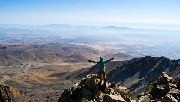 Turista Stojící Vrcholu Sopečné Hory Zdviženýma Rukama — Stock fotografie