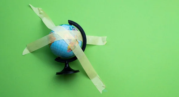 Globe Sticked Masking Tape Isolated Green Background Wit Copyspace World — Stock Photo, Image