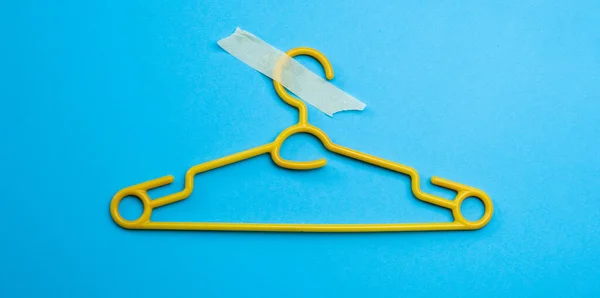 Kunststof Hanger Met Masking Tape Geïsoleerd Blauwe Achtergrond Met Kopieerruimte — Stockfoto