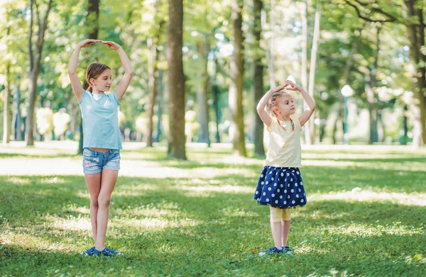 Beautiful Girl Her Little Sister Making Ballet Training Together Park — Stockfoto