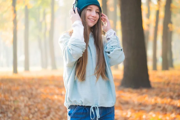 Porträt Eines Hübschen Mädchens Mit Kopfhörern Auf Verschwommenem Herbsthintergrund — Stockfoto