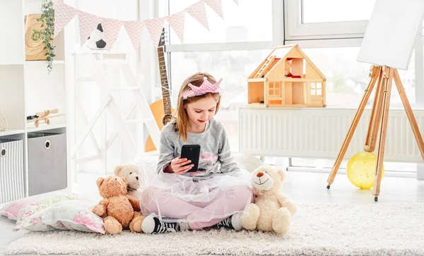 Lovely Little Girl Holding Phone Sitting Floor Plush Teddies — Zdjęcie stockowe