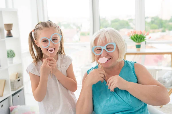 Menina Feliz Com Avó Colocando Óculos Lábios Paus Sala Luz — Fotografia de Stock