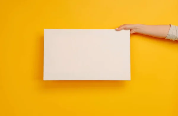 Hand Holding White Canvas Paper Blank Copyspace Yellow Background Empty — Stock Photo, Image