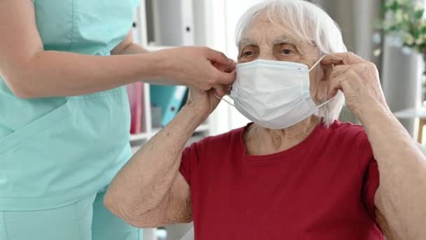 Senior Woman Wearing Mask Nurse Helps Her Protect Herself Pandemic — Video Stock
