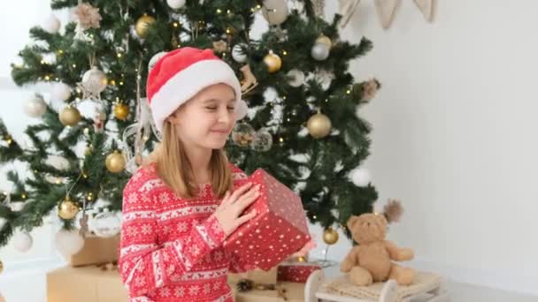 Pretty Child Girl Opens Gifts Christmas Tree Wearing Red Santa — Stockvideo