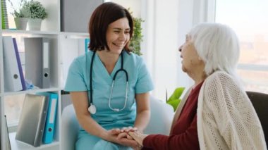 Klinikteki randevu sırasında doktorla yaşlı kadın arasında dostça bir konuşma.