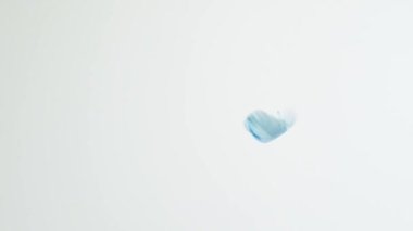 Dekoratif mavi tüy yavaşça yere düşüyor. Kabarık tüylü güzel sanat eserleri