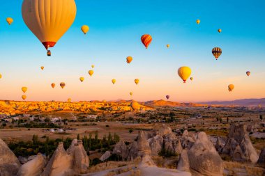 Gün batımında gökyüzünde yüzen parlak sıcak hava balonları