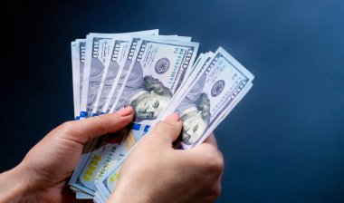 Yüz dolarlık banknotları tutan kişi nakit sayar. Amerikan para birimi