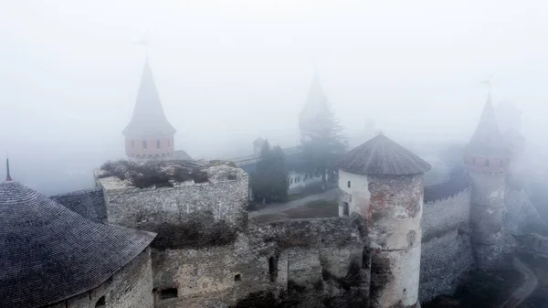 カメネッツ ポドルスキー 空中から霧の多い天気でウクライナの古代の要塞遺産 ドローンから雲の中に本物の塔を持つ中世の古い城 — ストック写真