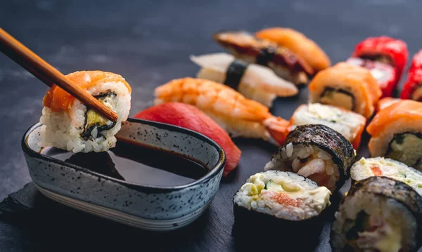 Pessoa Segurar Rolo Maki Sushi Com Pauzinho Colocá Molho Soja — Fotografia de Stock