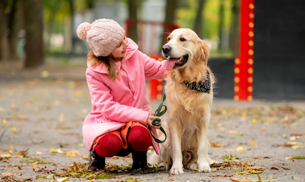 리트리버 데리고 공원에 앉아서 강아지를 쓰다듬는 가을에 동물을 기르는 — 스톡 사진