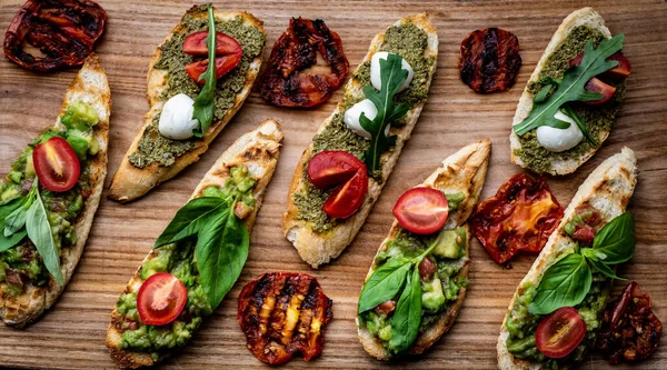 Set Bruschettas Pesto Guacamole Grilled Tomatoes Mozzarella Cheese Basil Arugula — Stock Photo, Image