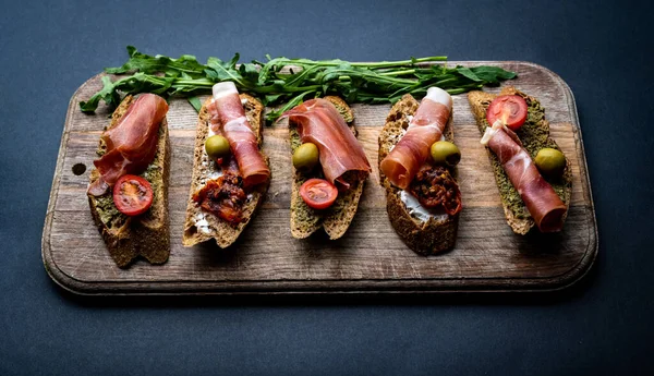 Bruschettas Jamon Ελιές Πέστο Τοματίνια Σχάρας Και Ντοματίνια Σερβιρισμένα Ξύλινη — Φωτογραφία Αρχείου