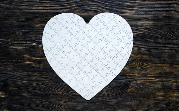 黑色桌子上的白色心形拼图是爱情 浪漫和感情的象征 — 图库照片