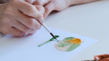 Sanat dersinde suluboya boyayla basit işler yapan yetenekli bir kız.
