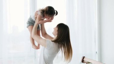 Güneşli bir dairede güzel bir aile sabahı. Anne yatak odasında küçük kızıyla oynuyor ve onu kusuyor. Anne ve küçük kız gün ışığında odada..