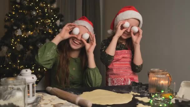 Meninas Sorridentes Chapéus Santa Segurando Ovos Frente Dos Olhos Durante — Vídeo de Stock