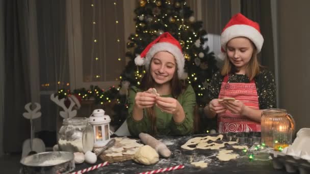 Smiling Sisters Santa Hats Preparing Gingerbread Men Room Decorated Christmas — Stock Video