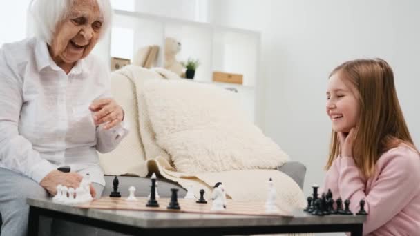 Γιαγιά Χαμογελά Την Εγγονή Κατά Διάρκεια Του Παιχνιδιού Σκάκι — Αρχείο Βίντεο