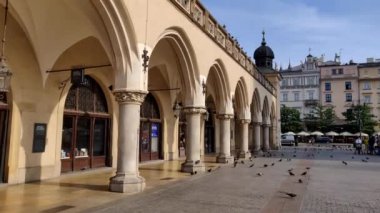 Krakow, Polonya - 19 Eylül 2018: Polonya 'nın Krakow kentinin merkez meydanındaki Sukiennice ve Tarihi Müze boyunca yürümek