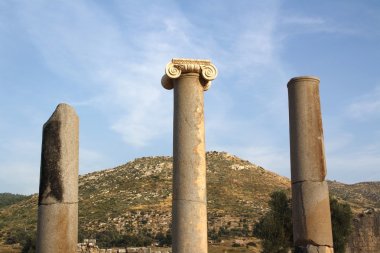Antik Yunan sütunları karşı mavi gökyüzü ve dağlar